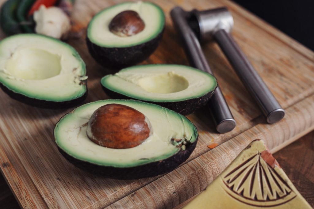 Halved avocados on a cutting board